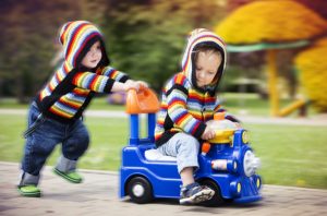 車の玩具に乗ってる子供（加工後）